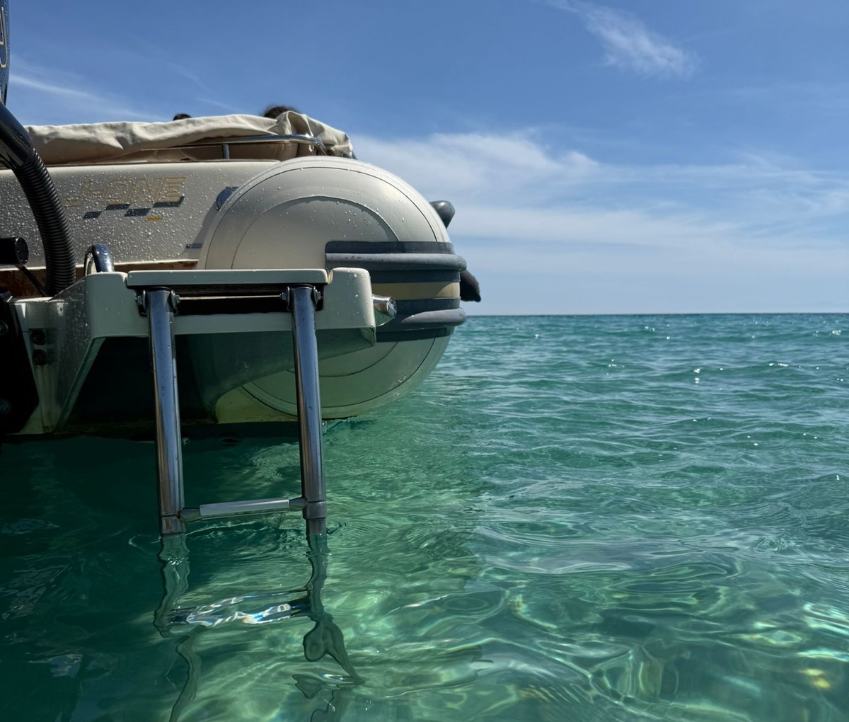Scaletta del gommone su acqua cristallina